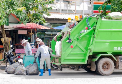 Operatives clearing garden debris with protective equipment